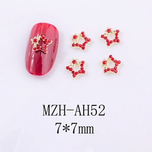 Détails de bijoux à ongles en strass rouges et cadres en or sur des ongles rouges