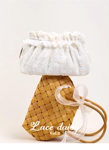 Detail of white lace daisy pouch on woven basket with delicate ruffle trim and floral embroidery