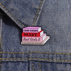 Pin's en émail avec pile de livres et texte sur une veste en jean délavé