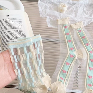 Detail of light blue mesh socks with heart patterns and geometric sheer fabric design