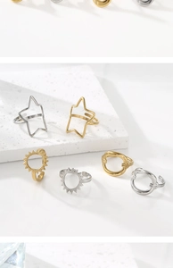Macro view of geometric open rings in gold and silver finishes on stone display