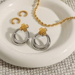 Two-tone 18k gold stainless steel ribbed twist earrings set on ceramic tray