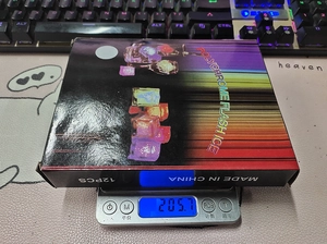 Weight measurement of 12PCS LED flash ice cubes pack showing 205.7g on a digital scale