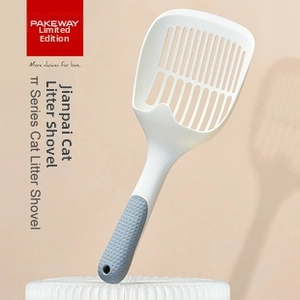 Macro detail of white ABS cat litter scooper with grey rubber handle on round pedestal