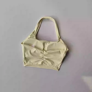 Detail view of the lime yellow ruched halter sports bra featuring a pleated chest design