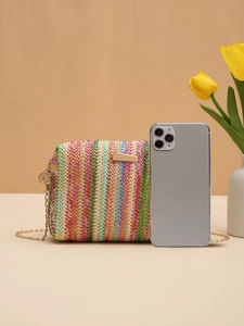 Colorful woven straw bag with gold chain strap shown next to a smartphone for size reference