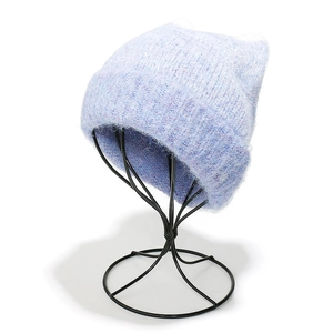 Macro detail of soft light blue knit beanie with cat ears on a metal display stand