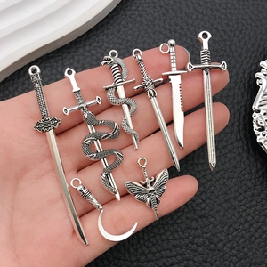 Silver zinc alloy sword and dagger charms set held in hand for jewelry making DIY
