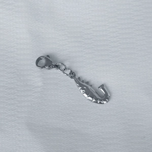 Detailed shot of silver stainless steel starfish pendant with lobster clasp on fabric