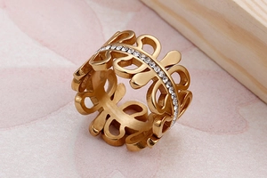 Macro shot of gold-plated hollow ring featuring white zircon inlays and floral petal design