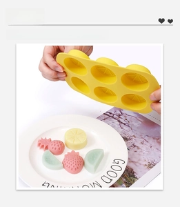 Detail showing flexible fruit-shaped silicone mold with easy-release pineapple and strawberry shapes