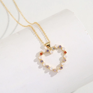 Elegant gold heart pendant necklace featuring white pearls and colorful zircon gemstones