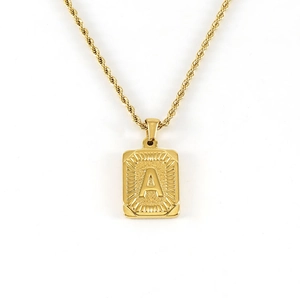 Détail du pendentif carré plaqué or 18K avec gravure lettre A et chaîne torsadée