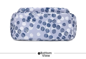 Detail view of the wide bottom of a lavender floral nylon shoulder bag with blue patterns