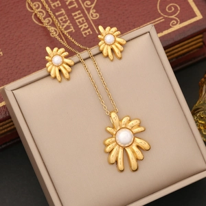 Golden flower jewelry set with pearls featuring necklace and earrings in a gift box