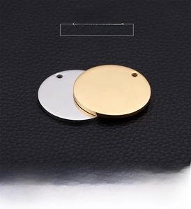 Close-up of polished gold and silver round metal pendants on a premium black leather texture