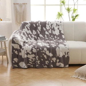 Thick faux fur cow print blanket in grey and white, soft throw for sofa or bedroom decor