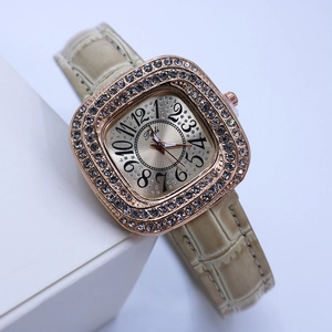Detail of square rose gold watch with sparkling rhinestones and beige leather strap
