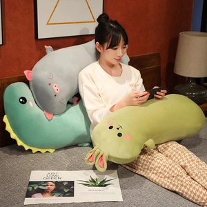 Cute dinosaur, pig, and rabbit long plush pillows displayed on a cozy home bed