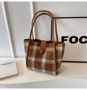 Detail of vintage brown plaid tote bag with leather straps and large capacity for commuting