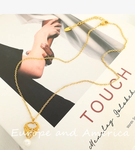 Close-up of golden pearl heart pendant necklace on a fashion magazine background