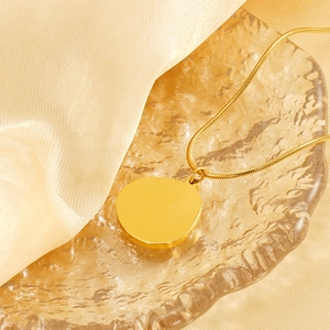 Vintage gold starburst tarot necklace on champagne silk background with glass tray
