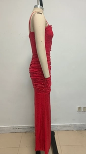 Side view of red sequin evening dress with waist pleats and heart cutout detail