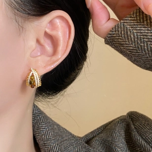 Close-up of vintage gold hoop earrings with brown tiger eye beads and micro diamonds