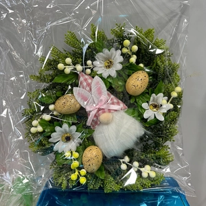 Detailed view of Easter wreath with pink plaid gnome, colorful eggs and daisies