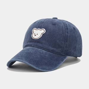 Detail of dark blue washed cotton baseball cap with cute white bear embroidery patch