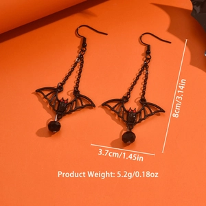 Detailed view of Gothic black bat earrings with size specs on orange background