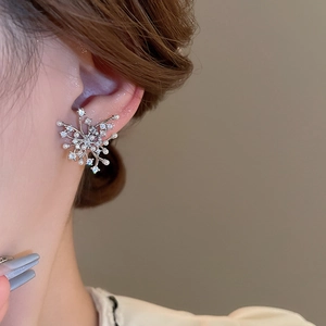 Close-up of model wearing silver snowflake earrings with white zircons and pearls