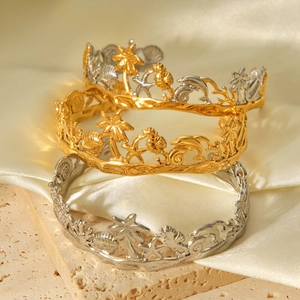 Detail view of open bangles with tropical ocean motifs like palm trees and shells