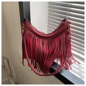 Detail of burgundy tassel hobo bag featuring fine fringe texture and gold metal hardware