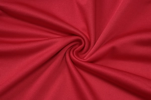 Vista dettagliata della trama del tessuto a maglia rosso scuro e del drappeggio morbido