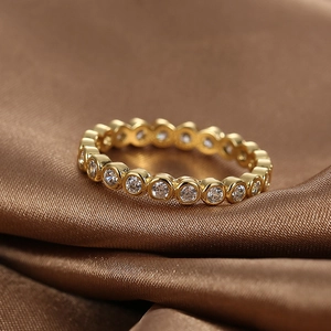 Elegant gold-plated brass eternity ring with micro-paved white zircons on brown satin fabric