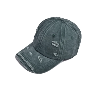 Detailed view of distressed holes and frayed edges on dark grey washed baseball cap