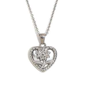 Collier en acier argenté avec pendentif cœur ajouré et fleur sur fond blanc impeccable