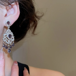 Elegant drop earrings featuring purple and white zircon stones shown on a model side view
