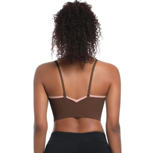 Detailed back view of criss-cross strappy sports bra with pink piping on deep brown fabric