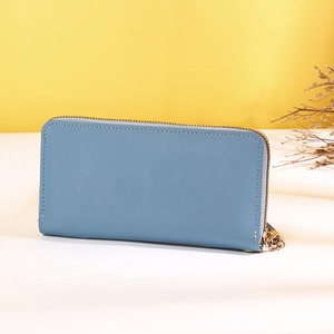 Vue latérale d'un portefeuille long en cuir bleu brume avec fermeture éclair dorée