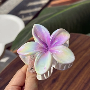 Close-up of a pearlescent flower hair claw clip with holographic laser finish