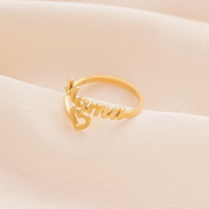 Goldener Mama-Ring mit hohlem Herz-Design auf elegantem rosa Seidenhintergrund