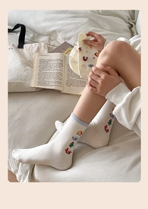 Détail de chaussettes de Noël mi-mollet avec broderie délicate sur coton tricoté beige doux