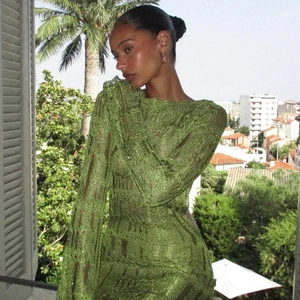 Close-up of green knit long sleeve dress showing hollow out mesh texture and details