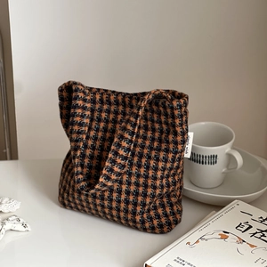 Detail of wool houndstooth mini tote bag featuring woven texture and simple side label