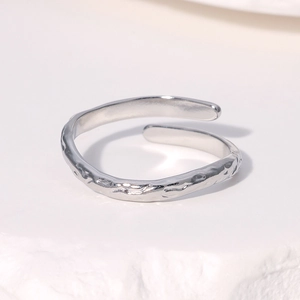 Anello regolabile argento irregolare con texture martellata su superficie in pietra