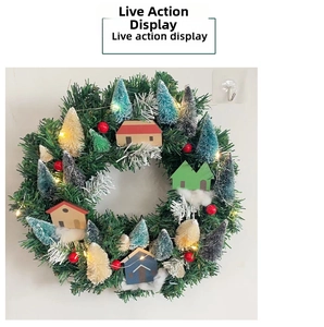 Detail view of glowing Christmas wreath featuring miniature houses and colorful brush trees