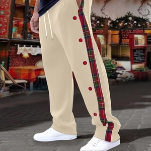 Detailed side view of beige casual pants featuring red plaid patches and decorative buttons