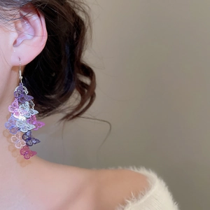 Détail des boucles d'oreilles papillon ajourées avec pampilles dégradées violettes